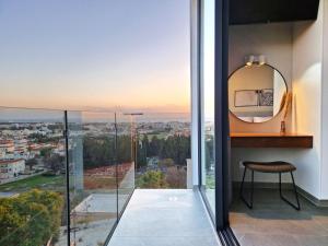 a mirror and a stool in a room with a view at Aeon Residences - In the heart of Paphos in Paphos City
