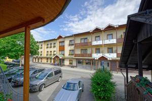 un gran edificio con coches estacionados en un estacionamiento en Hotel Stocker en Krieglach