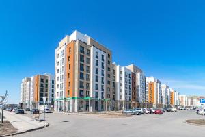un edificio alto en una calle con coches aparcados en Просторная квартира в Expo Boulevard, en Astana
