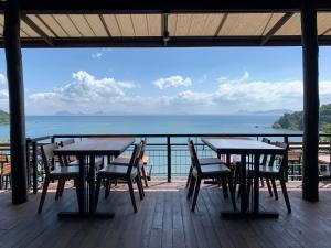 a patio with tables and chairs and the ocean at HEAVEN HILL LANTA in Ko Lanta