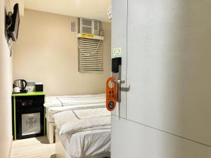 une chambre d'hôpital avec deux lits et une porte ouverte dans l'établissement 利珀旅舍 live Pop B&B, à Hong Kong