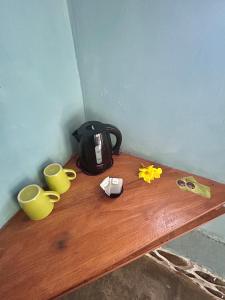 una mesa con dos tazas y una bolsa en ella en Aussie Inn Bukit Lawang, en Bukit Lawang