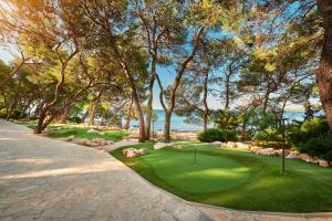 a golf course with a putting green and the ocean at Pine Beach Mobile homes all inclusive in Pakoštane