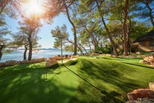 a golf course with a putting green and the ocean at Pine Beach Pakostane Glamping Homes - All Inclusive light in Pakoštane