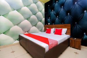 1 dormitorio con 1 cama con almohadas rojas en OYO Hotel K-sav Inn, en Phagwāra