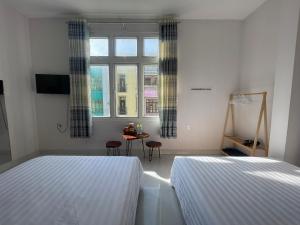 Postel nebo postele na pokoji v ubytování Đảo Hoa Dalat Hotel
