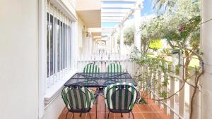 un tavolo nero e 2 sedie sul balcone di Garden vistas. Hermoso dúplex con patio, solárium y piscina. a Vera