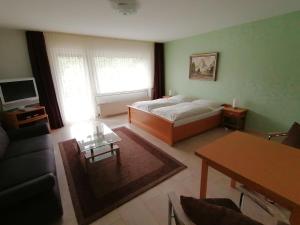 ein Wohnzimmer mit einem Bett und einem Tisch in der Unterkunft Gästehaus Tannenhof in Clausthal-Zellerfeld
