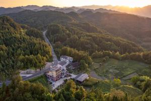 an aerial view of a house in the middle of a forest at 恩施硒坪民宿 Enshi Xiping Homestay in Enshi
