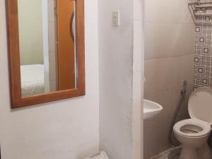 a bathroom with a toilet and a mirror at RedDoorz near Pantai Pandan Sibolga 2 in Halangan