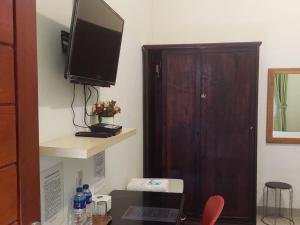 a room with a television on a wall with a cabinet at RedDoorz near Pantai Pandan Sibolga 2 in Halangan