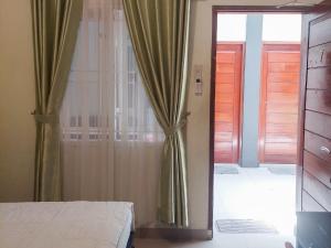RedDoorz near Pantai Pandan Sibolga 2 في Halangan: غرفة نوم مع باب مفتوح على غرفة بسرير