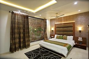 a bedroom with a large bed and a window at Adhyas Castle in Morbi