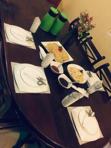 a wooden table with plates of food on it at Himawari Hills in Nuwara Eliya