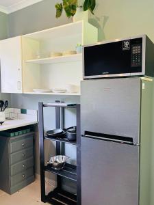 a kitchen with a refrigerator with a microwave above it at Robyns Nest 2 Studio Cottage in Kloof