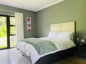 a bedroom with a large bed and a window at Robyns Nest 2 Studio Cottage in Kloof