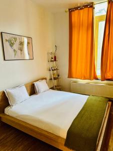 a bedroom with a large bed with an orange curtain at Down-Town 1 Bedroom Flat in Brussels