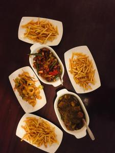 a table topped with plates of food and french fries at Himawari Hills in Nuwara Eliya
