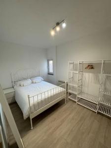 Apartamento 12 de Octubre, Almendrales في مدريد: غرفة نوم بسرير أبيض وسريرين بطابقين