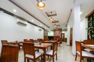 a dining room with wooden tables and chairs at Hotel Elite Millennium - Near Huda City Centre Gurgaon in Gurgaon