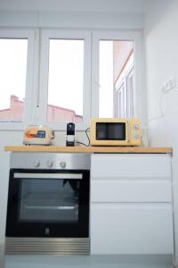 a kitchen with a counter with a microwave and a stove at Apartamento 12 de Octubre, Almendrales in Madrid