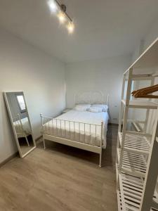 Un dormitorio con una cama blanca y una escalera en Apartamento 12 de Octubre, Almendrales, en Madrid