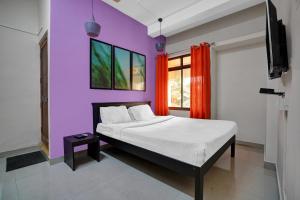 a bedroom with a bed and a purple wall at Collection O Lala Homes in Alwaye