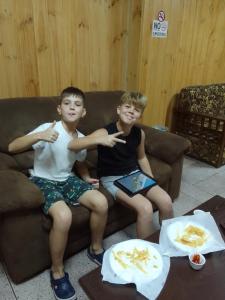 two young boys are sitting on a couch at Himawari Hills in Nuwara Eliya