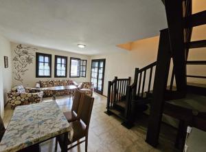 uma sala de estar com um sofá e uma mesa em Вилна Къща Кедър em Dolna Banya