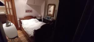 - une petite chambre avec un lit et un miroir dans l'établissement MENFOUTI, à Saint-Béat