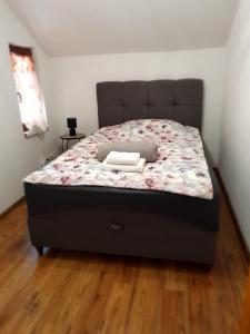 un grande letto in una camera da letto con pavimento in legno di Apartman Magdalena a Knin (Tenin)
