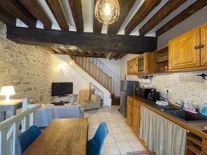 a kitchen with a table and a dining room at Escapade Moretaine - L'Echappée au charme d'antan in Moret-sur-Loing