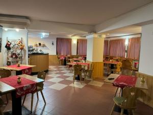 un restaurante con mesas y sillas en una habitación en Life Hotels Des Alpes, en Folgaria
