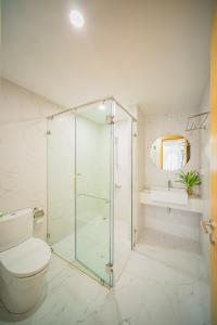 bagno con doccia in vetro e servizi igienici di Song Suoi Quy Nhon Beachfront Apartment a Quy Nhon