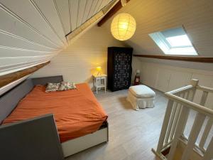 a attic bedroom with a bed and a window at Escapade Moretaine - L'Echappée au charme d'antan in Moret-sur-Loing