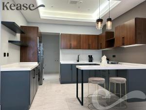 a kitchen with blue cabinets and a island with stools at Kease King Salman S-6 Lusso Najd XZ90 in Riyadh