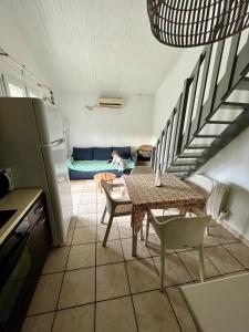a kitchen with a table and chairs and a staircase at Petite maison à 100m de la plage in Marseillan