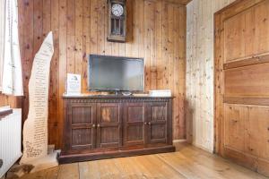 a room with a television on a wooden wall at Hauserlhütte in Zederhaus