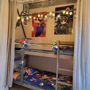 Chez Christy Chemin des Dinots في Saint-Bonnet-de-Four: غرفة نوم للأطفال مع سريرين بطابقين مع أريكة