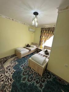 a bedroom with two beds and a rug at Гостевой дом "BAXSHILLO" in Bukhara +6 photos
