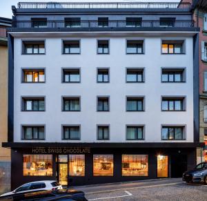 un edificio blanco con fachada de tienda en Swiss Chocolate by Fassbind Lausanne en Lausana