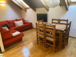 a living room with a table and a red couch at Casa Tramatorcuato in Tramacastilla de Tena