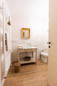 a bathroom with a sink and a toilet at Casa vacanze Dentro le Mura in Gualdo Tadino