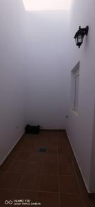 a room with a white wall and a light and a tile floor at SUIT del CAMPO AMANAY in Tuineje