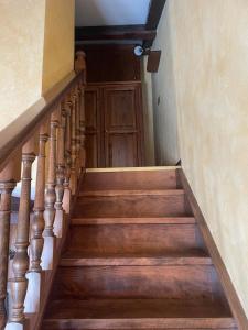 uma escada com escadas de madeira e uma porta de madeira em B&B Borgata 2000 em Borgata Sestriere