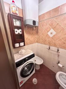 a bathroom with a washing machine and a toilet at B&B Borgata 2000 in Borgata Sestriere