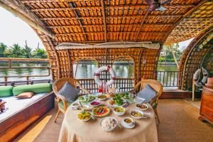 Spice Coast Cruises - Houseboat في أليبي: طاولة مع أطباق من الطعام على متن قارب