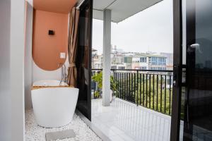 河內的住宿－AimeeHouse - Trích Sài，带浴缸的浴室和阳台。