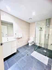 a bathroom with a shower and a toilet and a sink at Apartment in Turrella in Sydney