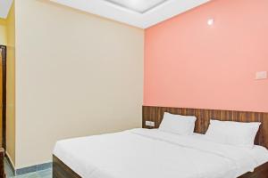 a bed in a room with a pink wall at Flagship Hotel Patil 2 in Nagpur